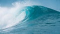 CLOSE UP: Glassy droplets of ocean water fly away from spectacular tube wave. Royalty Free Stock Photo