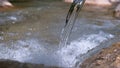 CLOSE UP: Glassy river water flowing over the rocky riverbed on a sunny day. Royalty Free Stock Photo