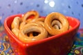 Close-up glazed bagels on red plate in shape of heart. Selective Royalty Free Stock Photo