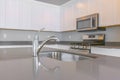 Close up of a glossy countertop with faucet and sink inside a modern kitchen Royalty Free Stock Photo