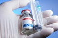 close up of gloved hand holding coronavirus vaccine vial, syringe and needle Royalty Free Stock Photo