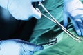 Close-up of gloved hands holding the surgical scissors and working, operating room, hospital Royalty Free Stock Photo