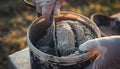 Mixing Concrete in a Bucket with Gloved Hands Royalty Free Stock Photo