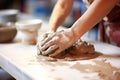 a close-up of gloved hands molding clay