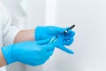 Close-up of a gloved nurse taking a sterile needle from a package