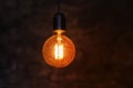 Close up glowing light bulb. Vintage lightbulb on dark background with bright yellow shining wire Royalty Free Stock Photo