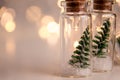 Close up of glowing lights decoration of glass jars with corks inside which there are small green Christmas trees on artificial