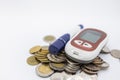 Close up of Glucode meter with lancet for check blood sugar level on pile of coins on white background. Money, Medicine, diabetes Royalty Free Stock Photo