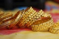 Close up of gold bangle in a brown backdrop