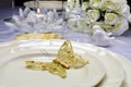 Close up of gold butterful wing on wedding table plates Royalty Free Stock Photo