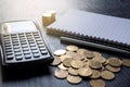 Close up gold coins, calculator, pen, notebook on black table. Business, finance, marketing, e-commerce concept and design Royalty Free Stock Photo