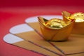 Close up on gold ingots on yellow packets. Chinese New Year celebration concept.