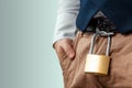 Close-up of a gold padlock hanging from a man`s belt. The concept of marital fidelity, celibacy, treason, chastity belt Royalty Free Stock Photo