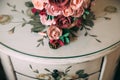 Close-up the gold rings of the newlyweds and the groom`s boutonniere lie on a wooden vintage table. A wedding bouquet of Royalty Free Stock Photo