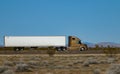 CLOSE UP: Gold truck speeds along the interstate highway crossing a desert Royalty Free Stock Photo