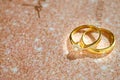 Close up of Gold wedding rings or engagement rings on wedding invitation card background. Royalty Free Stock Photo