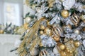 Close up golden balls and White flowers hanging on Christmas tree. Shining garland. holidays and seasonal greetings concepts. Royalty Free Stock Photo