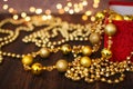 Close up golden christmas decoration balls from red gift box on dark wooden background and bokeh garland Royalty Free Stock Photo