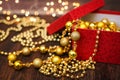 Close up golden christmas decoration balls from red gift box on dark wooden background and bokeh garland Royalty Free Stock Photo