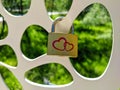 Close-up. Golden color lock with red hearts hangs on an iron fence on a summer day. The concept of family, love and fidelity Royalty Free Stock Photo