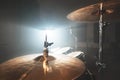 Close-up Golden cymbals Modern drum set prepared for playing in a dark rehearsal room on stage with a bright spotlight Royalty Free Stock Photo