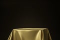 Close up of golden luxurious fabric placed on top pedestal or blank podium shelf on black background with luxury concept. 3D