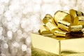 Close up Golden present box with big bow at bokeh white blur background, Leave space on top to adding your content Royalty Free Stock Photo