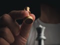 Close-up golden queen chess piece in human hand on dark background. Hand moving queen chess figure ready to attack the enemy.