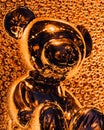 Close-up of a golden teddy bear with a reflection on the background of small balls Royalty Free Stock Photo