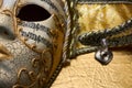 Close up of golden Venetian mask, fancy carnival mask with details and musical notes on golden surface