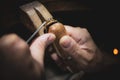 Close-up of goldsmith producing jewelry with his hands in his workshop