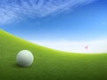 Close up golf ball on green grass field and red golf flag on green fairway with beautiful blue sky Royalty Free Stock Photo