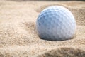 Close up golf ball in sand bunker shallow depth of field. A gol Royalty Free Stock Photo