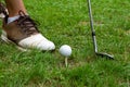 Close-up of golf club and cue ball on tee, and man`s foot with golf shoe, horizontally Royalty Free Stock Photo