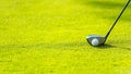 Close up Golf club hitting golf ball along with tee on green tee Royalty Free Stock Photo