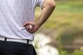 Close up of golfer holding golf ball and golf tee with golf course out of focus