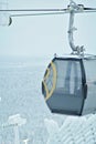 Close-up of a gondola lift or cable car going up the slope. Snow-covered fence and snowy forest in the background. Beautiful snowy Royalty Free Stock Photo