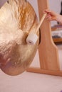 Close up of a gong with a handheld stick during a sound healing therapy healing session.