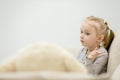 Close up of good-looking little girl with blonde hair thinking of something seriously. Royalty Free Stock Photo