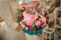 close-up of gorgeous flower bouquet wrapped in turquoise wrapping paper in woman hands