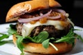 Close-up of a gourmet hamburger steak with caramelized onions, arugula, and garlic aioli on a toasted brioche bun