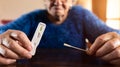 Close-up grandma hand holding a buffer dropper for seft detection of coronavirus Royalty Free Stock Photo