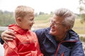 Close up of grandson and his grandfather in the countryside looking at each other, portrait, Lake District, UK