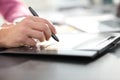 Close up. a graphic designer uses a graphics tablet sitting at D