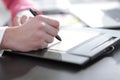 Close up. a graphic designer uses a graphics tablet sitting at Desk in Studio