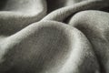Close-up of gray fabric with a fine weave pattern, showcasing its smooth texture and subtle draping folds