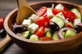 Close-up of Greek Salad with Cherry Tomatoes, Cucumbers, Feta Cheese, and Olives in a Wooden Spoon Royalty Free Stock Photo