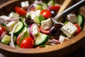 Close-up of Greek Salad with Cherry Tomatoes, Cucumbers, Feta Cheese, and Olives in a Wooden Spoon Royalty Free Stock Photo