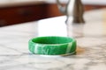 close-up of a green allergy wristband on a marble countertop