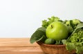 Close up green apple with mixed green vegetable in basket and wooden fork and spoon for healthy organic green food concept Royalty Free Stock Photo
